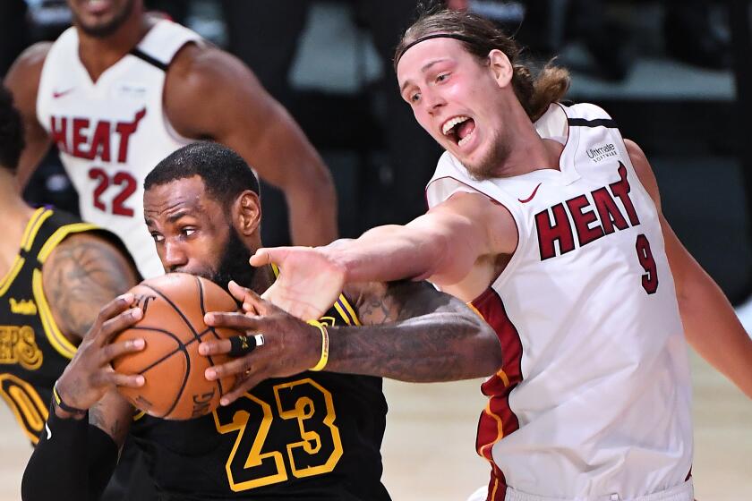 ORLANDO, FLORIDA OCTOBER 2, 2020-Lakers LeBron James grabs a rebound from Heat's Kelly Olynyk.
