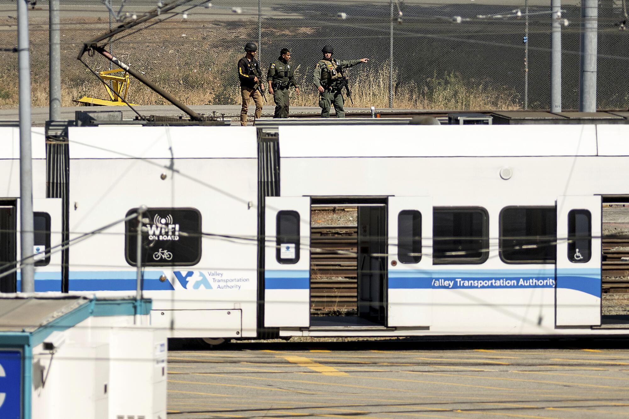 Three people on top of a train car.