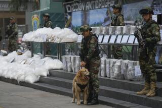 Agentes antinarcóticos transportan paquetes de cocaína incautada durante una presentación ante los medios en una base policial antinarcóticos en Lima, Perú, el lunes 6 de mayo de 2024. (AP Foto/Martín Mejía)