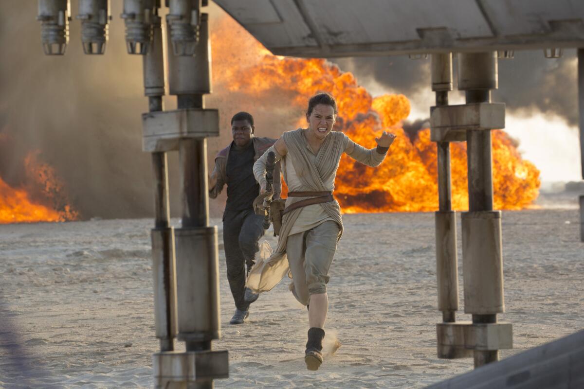 Daisy Ridley, right, as Rey and John Boyega as Finn in "Star Wars: The Force Awakens."
