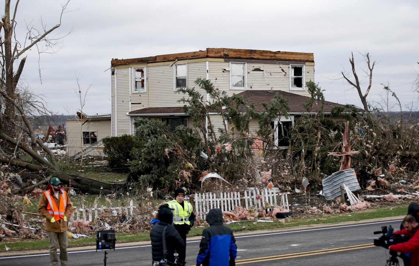 Locals inspect a home left in ruins in a destroyed neighborhood after a heavy storm in Fairland, Ill.