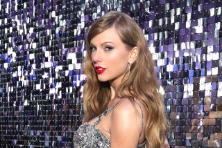 Taylor Swift  poses in a silver gown at a film premiere