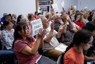 MURRIETA, CA - AUGUST 10, 2023: Attendees in support of the parental notification policy hold up signs stating "Protect Family Values" during a school board meeting which decided 3-2 to enact a policy which would notify parents if any child identifies as transgender on August 10, 2023 in Murrieta, CA. (Gina Ferazzi / Los Angeles Times)