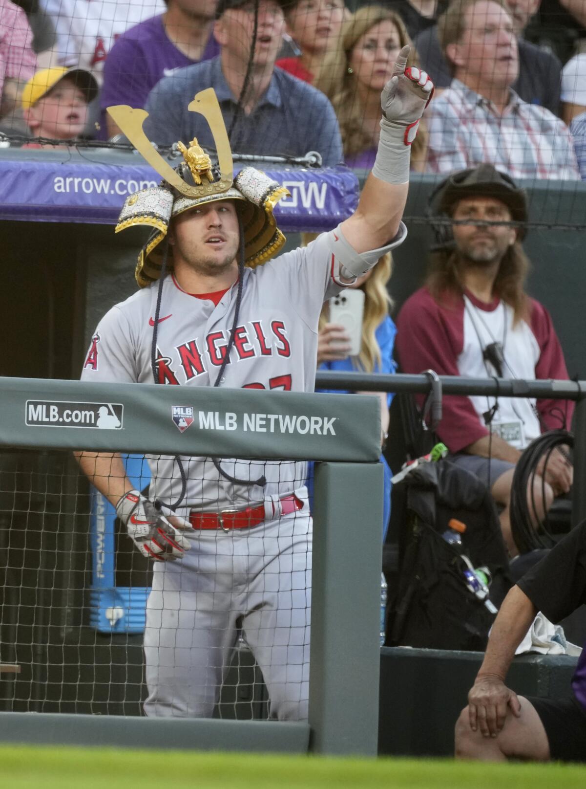 Mike Trout points up as he wears the team's home-run helmet.