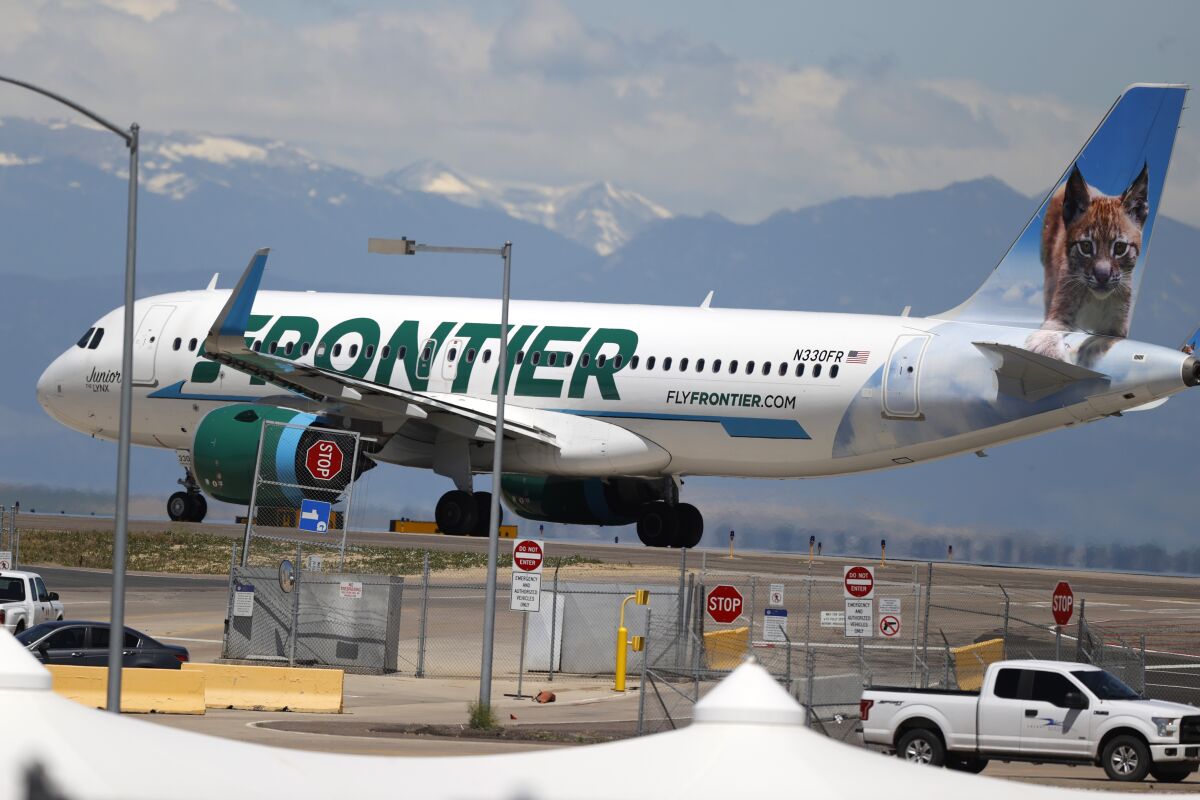 A Frontier Airlines jet heads down a runway for take-off. 