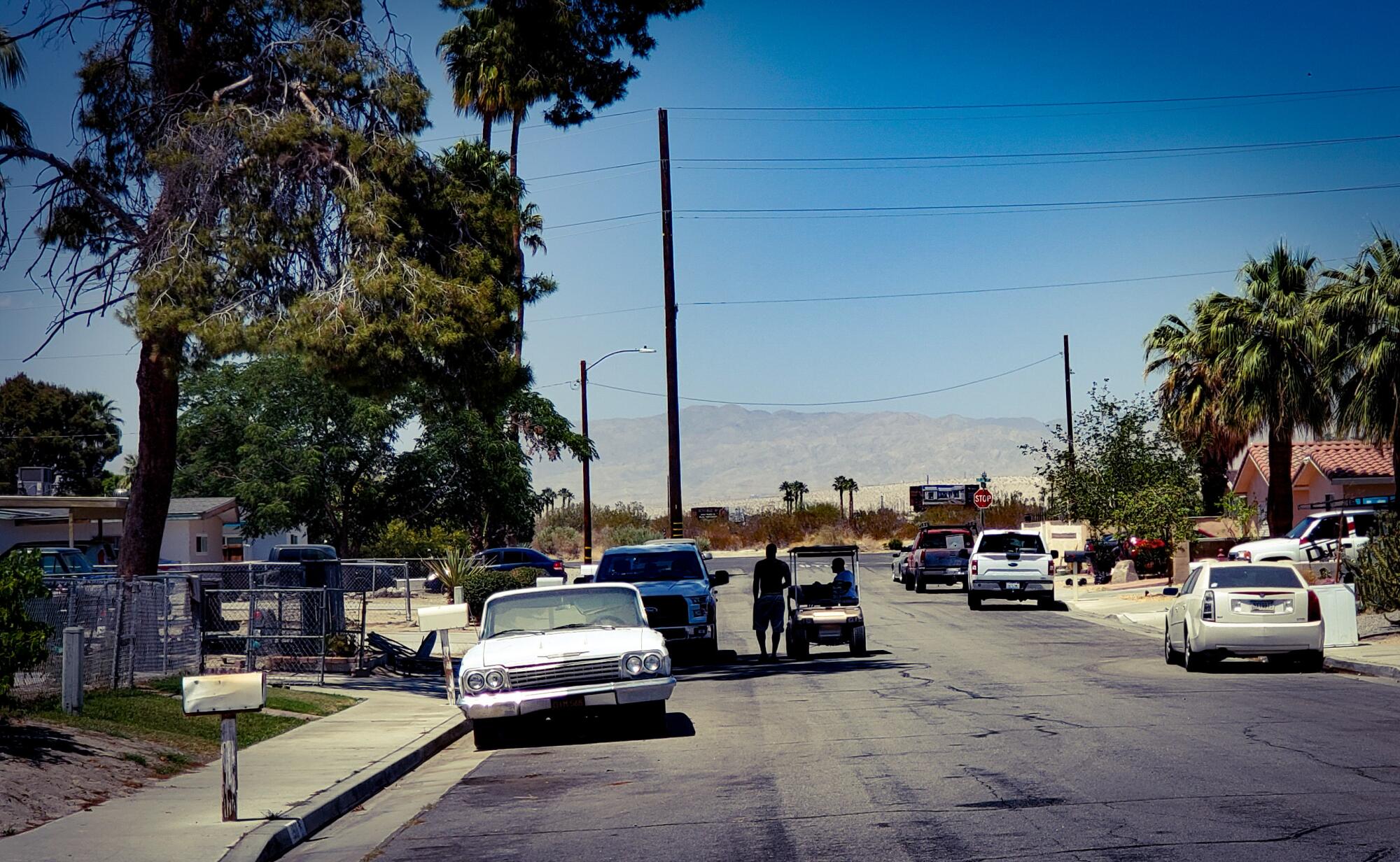 A modest residential street with a mountain in the background.