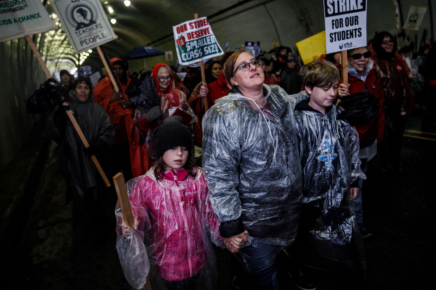 Corianne Cook, a teacher from Webster Middle School with her children, Ryn, 9, left, and Liam, 12, march to LAUSD district headquarters during the first day of the UTLA strike in Los Angeles.
