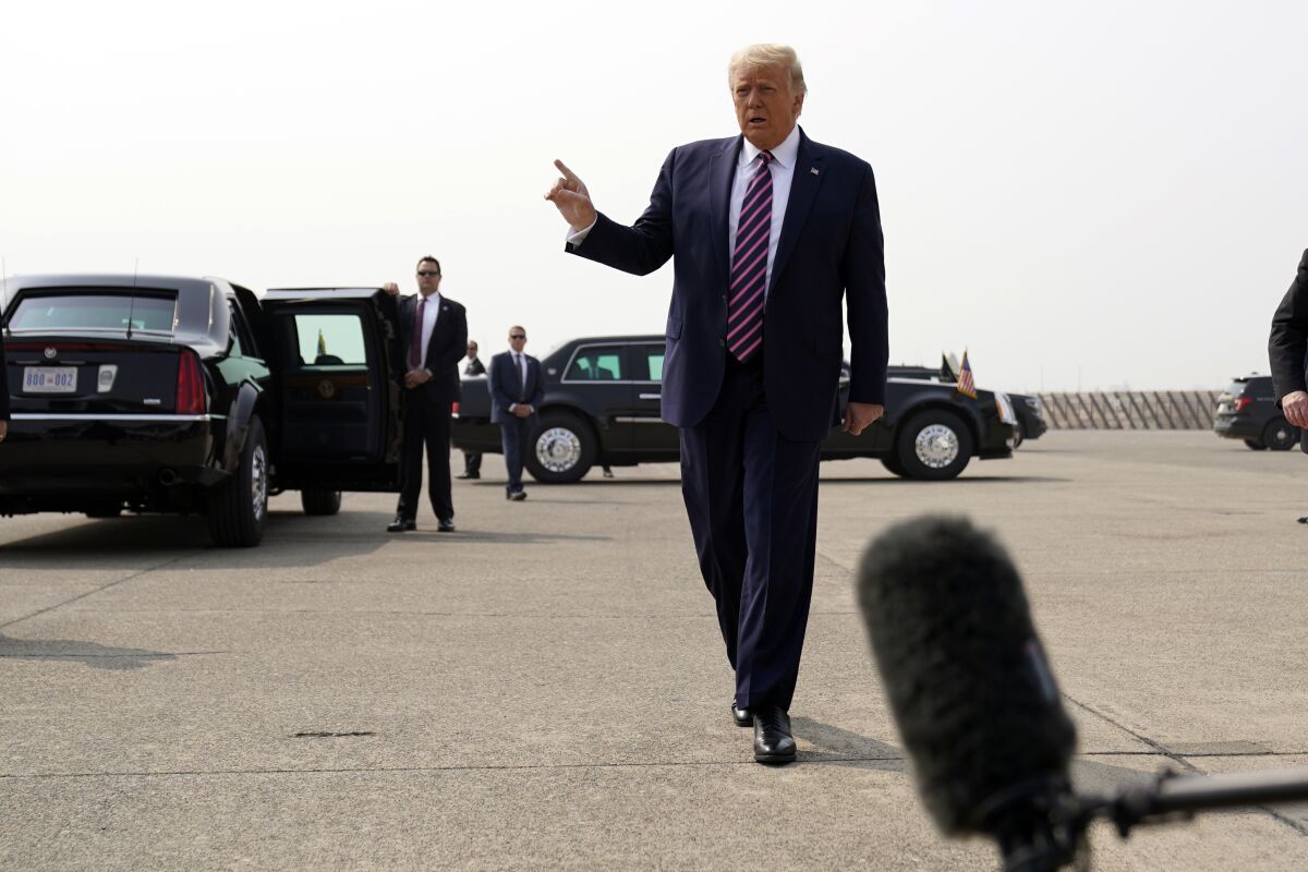 President Trump walks to speak to reporters as he arrives at Sacramento McClellan Airport.
