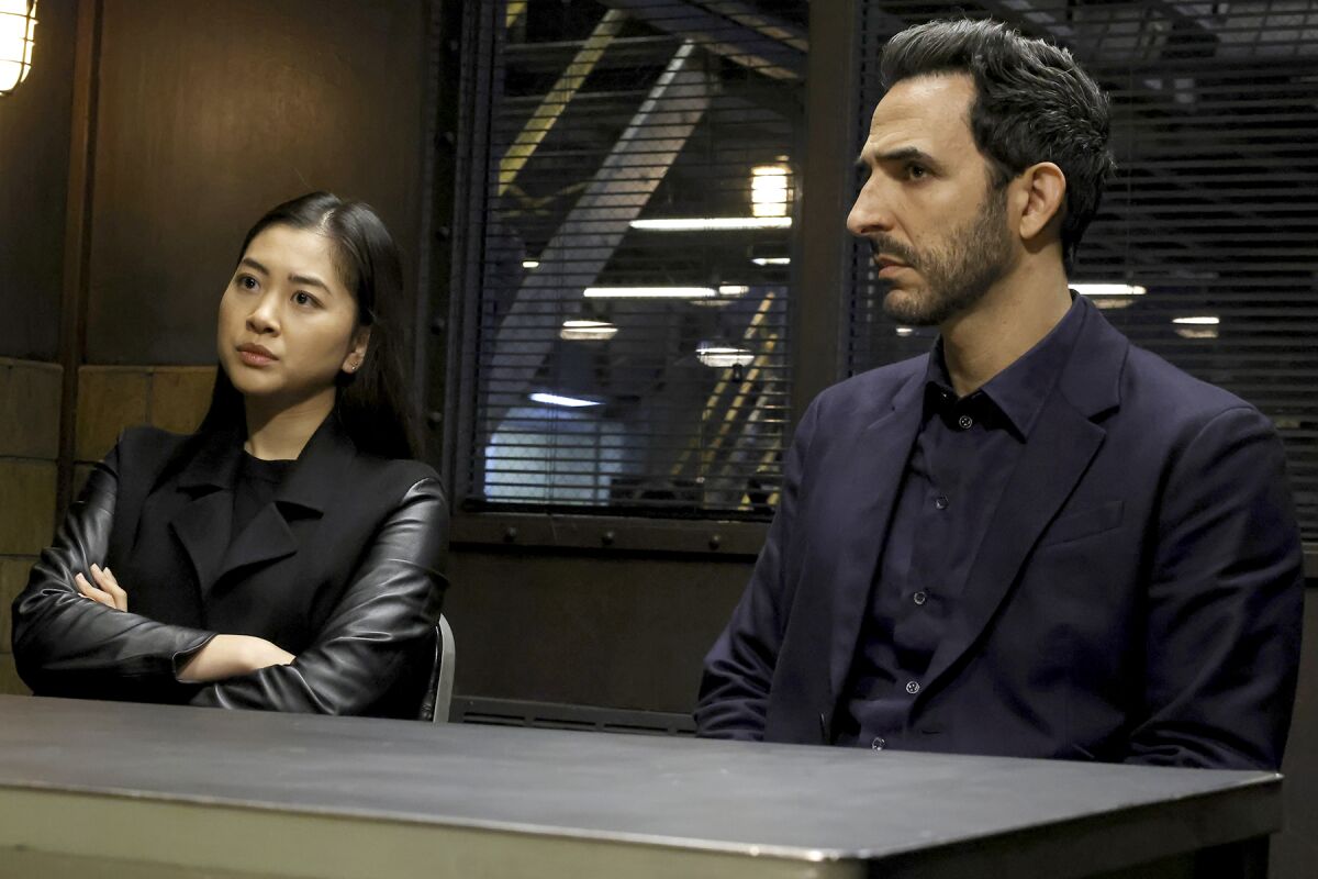 A woman and a man sit side by side at a table.