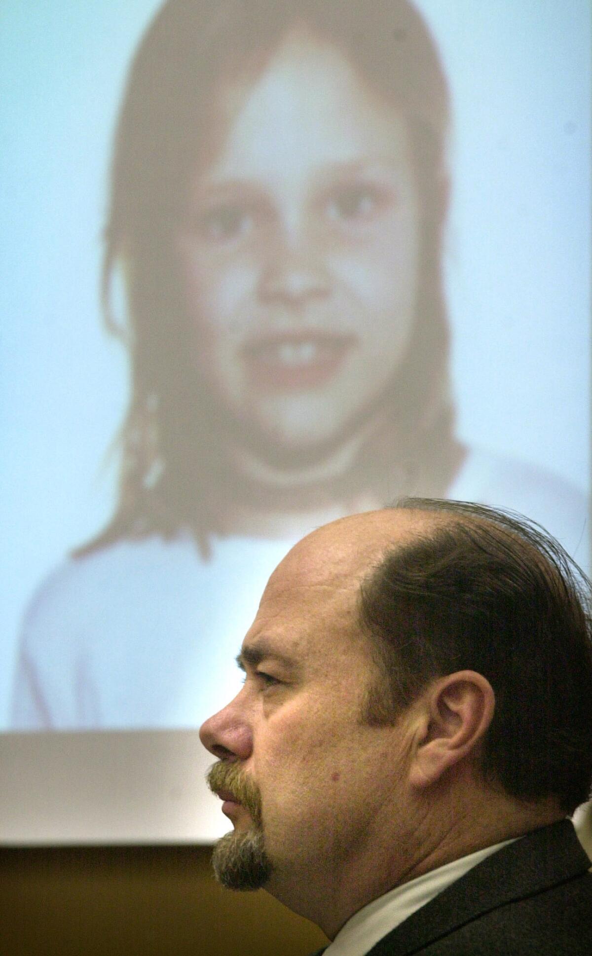David Westerfield sits in front of a photo of Danielle van Dam