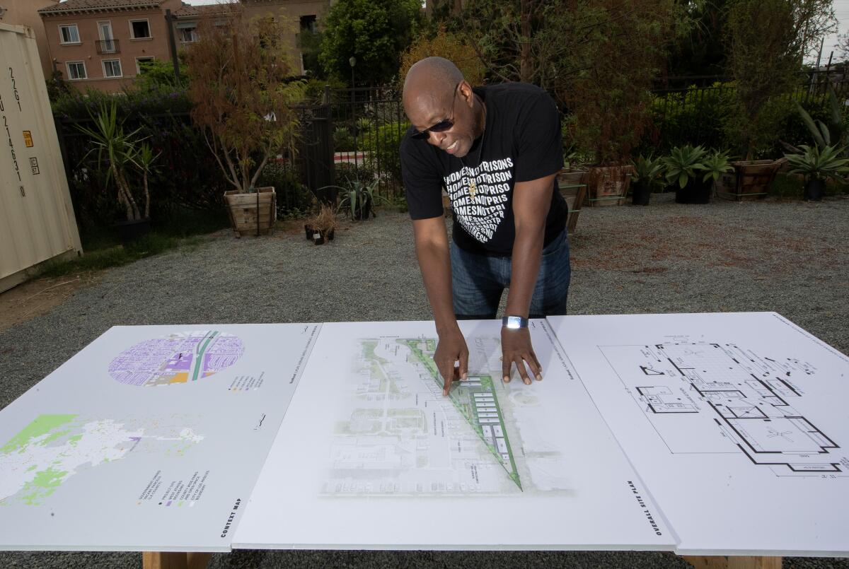 A man shows off architectural drawings 