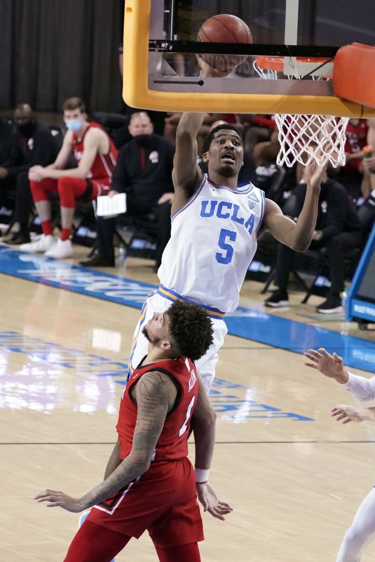 UCLA guard Chris Smith (5) shoots over Utah forward Timmy Allen during the second half of an NCAA college basketball game Thursday, Dec. 31, 2020, in Los Angeles. (AP Photo/Marcio Jose Sanchez)
