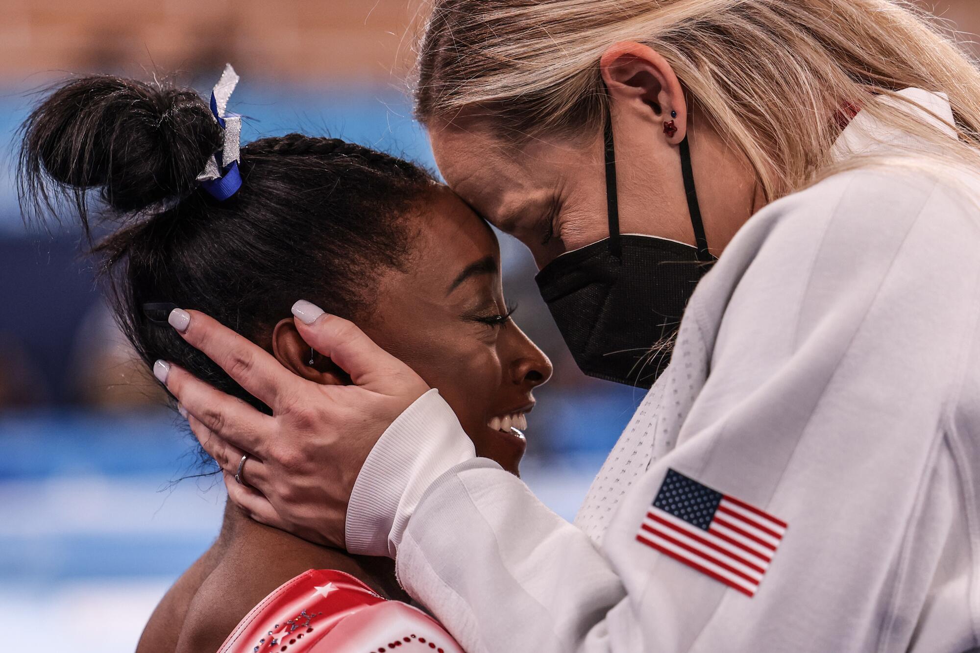 USA gymnast Simone Biles is congratulated by her coach Cecile Landi as it becomes evident she will earn a medal.