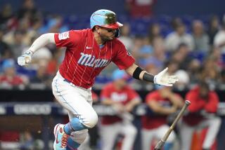 Miami Marlins' Miguel Rojas hits into a double play during the fourth inning.