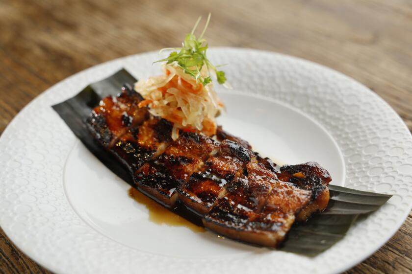 San Diego CA - April 16: Pork belly liempo (barbecue pork belly) with atchara (pickled green papaya salad) on Tuesday, April 16, 2024 in Escondido, CA. (K.C. Alfred / The San Diego Union-Tribune)