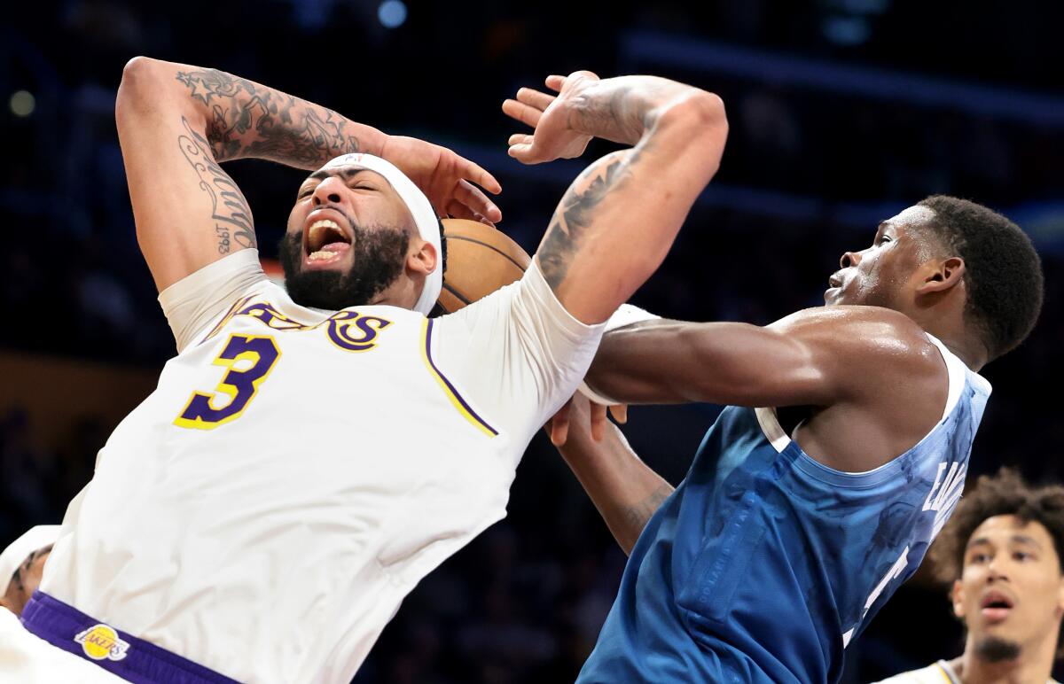Minnesota's Anthony Edwards, right, blocks a shot by Lakers forward Anthony Davis in the second half Sunday.