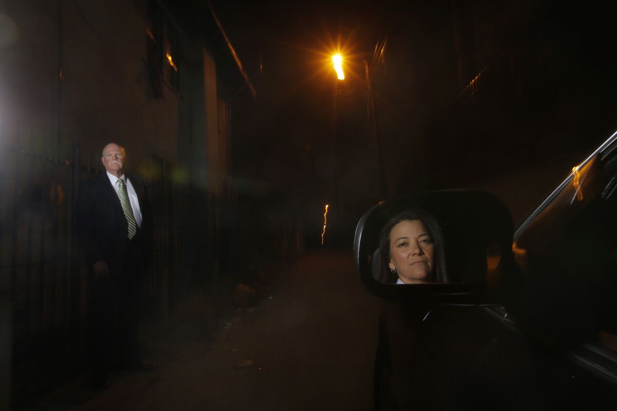 In this Thursday, March 14, 2013 photo, Los Angeles Police Detectives Rick Jackson, left, and Mitzi Roberts pause for photos
