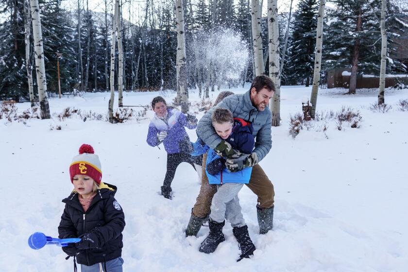 KETCHUM, IDAHO -- TUESDAY, DECEMBER 10, 2019: Carson Palmer gets hammered with a snowball as he tries to take a portrait with his children Carter, from left, Bries, Elle and Fletch in Ketchum, Idaho, on Dec. 10, 2019. (Marcus Yam / Los Angeles Times)