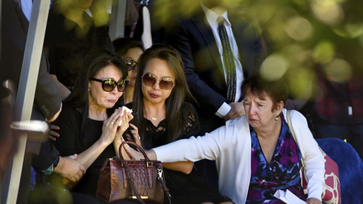 Erica Fischman, left, widow of Capital editor Gerald Fischman, is comforted by her daughter Uka Saran, center, and a relative during the gravesite service for Fischman on Sunday.