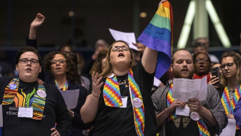 Shelby Ruch-Teegarden, center, protests during the United Methodist Church's special session of the general conference.