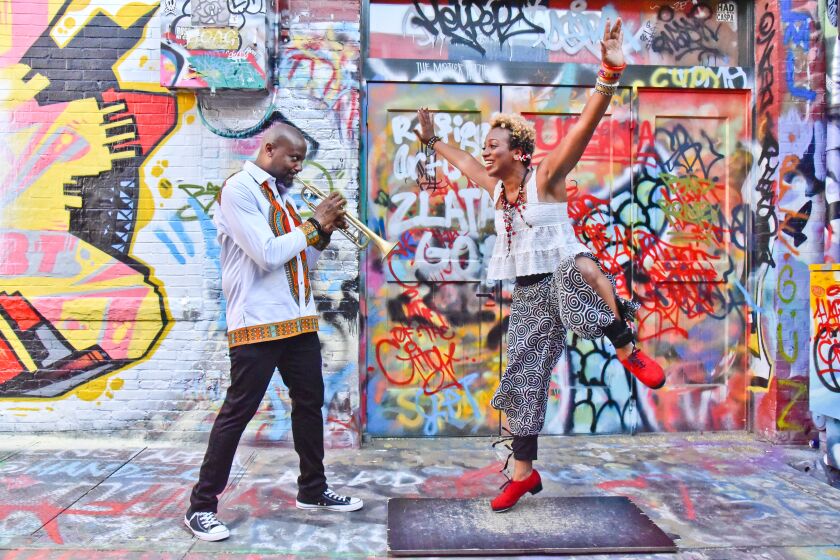 Trumpeter Sean Jones and vocalist/dancer Brinae Ali in front of a colorful mural