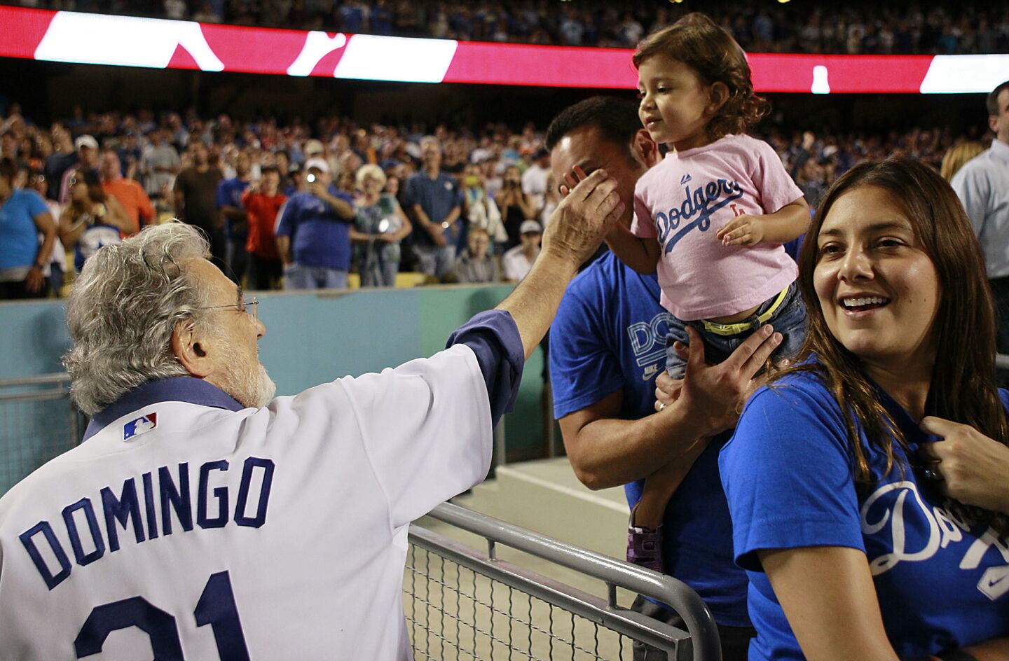 Opera star Placido Domingo greets a young Dodgers fan as he leaves the field after singing "God Bless America" and "Take Me Out to the Ball Game" during the seventh inning stretch at Dodger Stadium. More: Plácido Domingo leads an uptempo life