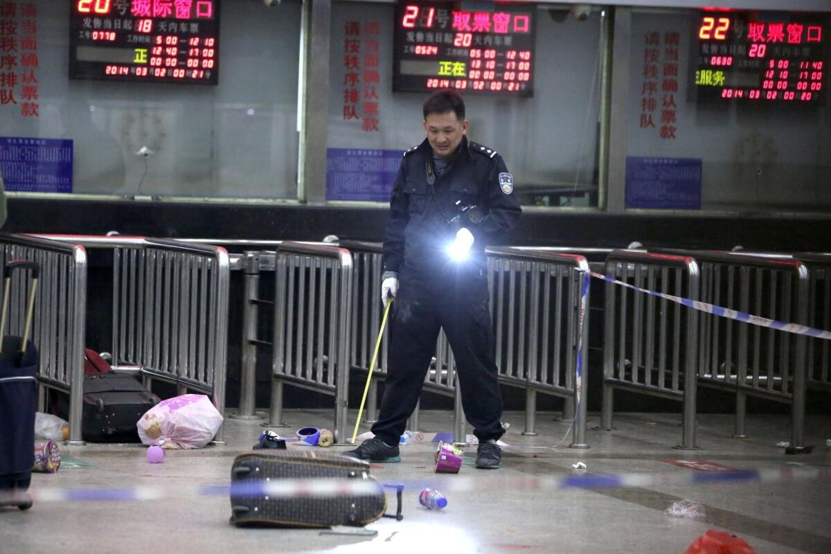A Chinese police investigator inspects the scene of the railway station attack in Kunming in March.