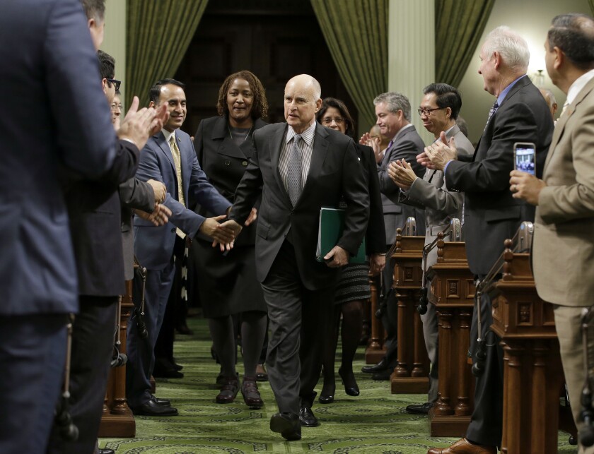 Gov. Jerry Brown is greeted by lawmakers as he enters the Assembly to deliver his annual State of the State address on Tuesday.