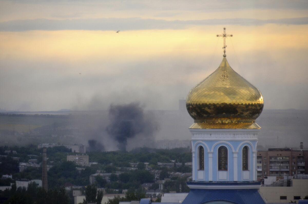 Black smoke billows at the site of a mortar attack Monday on the separatist-held eastern Ukrainian city of Luhansk.