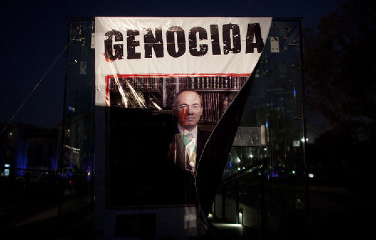 A banner with a defaced picture of Mexican President Felipe Calderon was hung by demonstrators protesting violence in Mexico City on Nov. 28, 2012. Mexico will inaugurate a new president Saturday after Calderon's six-year militarized offensive against drug cartels.