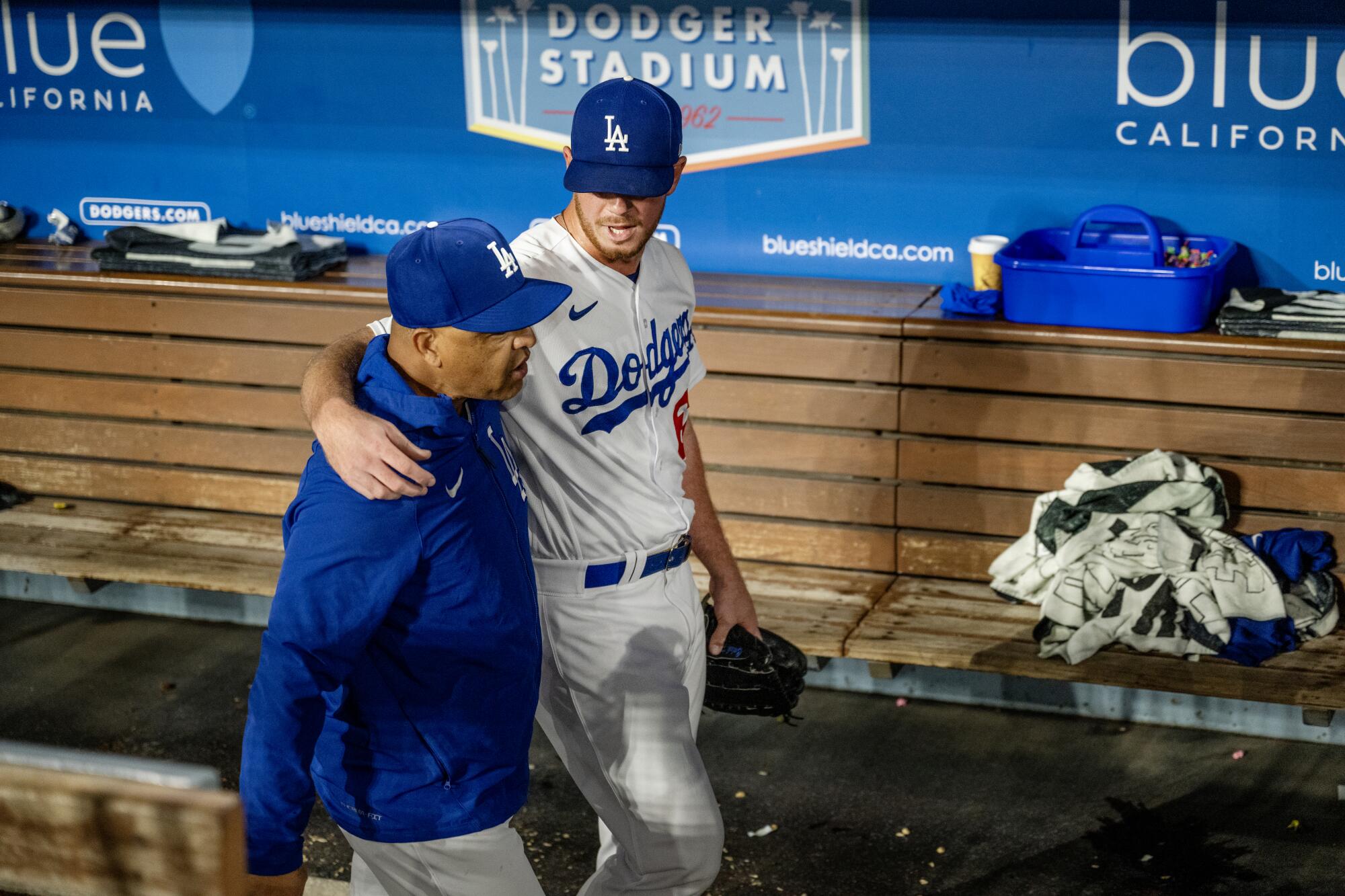 Dodgers relief pitcher Caleb Ferguson wraps his arm around Dodger manager Dave Roberts after a win.