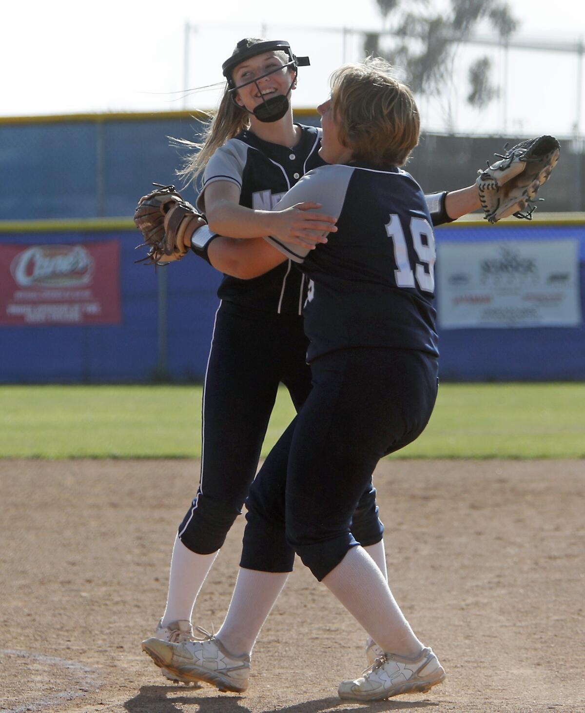Newport Harbor High starting pitcher Clare Austin, right, shares a hug with closer McKayla Cotton after the Sailors defeat Ocean View 3-2 in the first round of the CIF Southern Section Division 5 playoffs at home on Thursday.