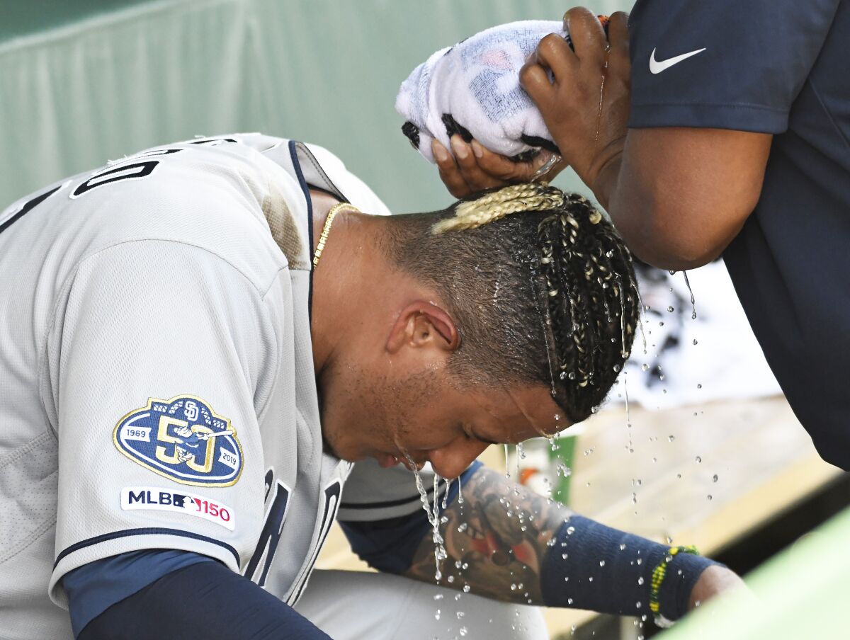 Manny Machado cools off in the Padres dugout after hitting a two-run home run against the Chicago Cubs in the third inning of Saturday's game at Wrigley Field.