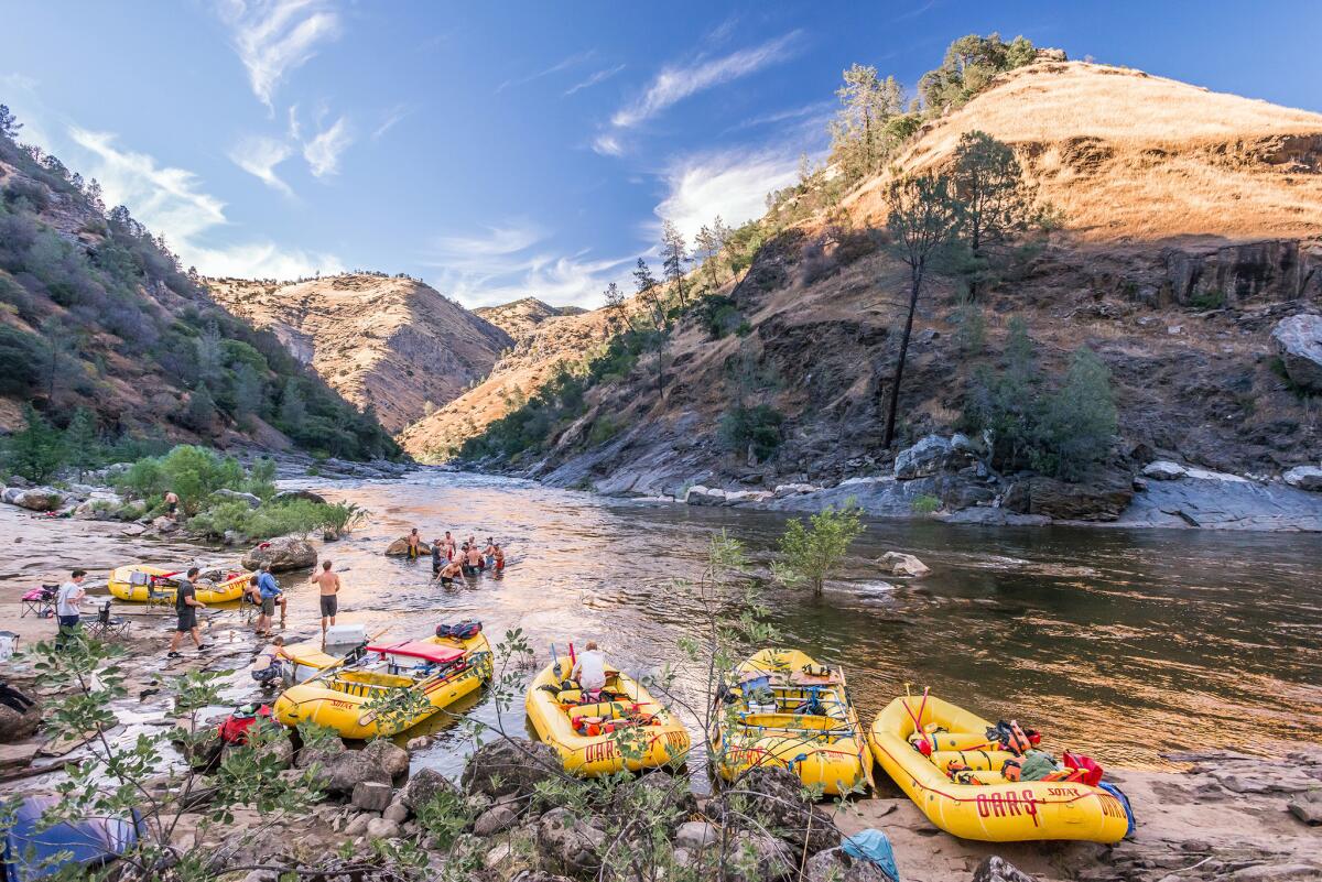 A group of OARS rafters hang out on the banks of the Tuolumne River.