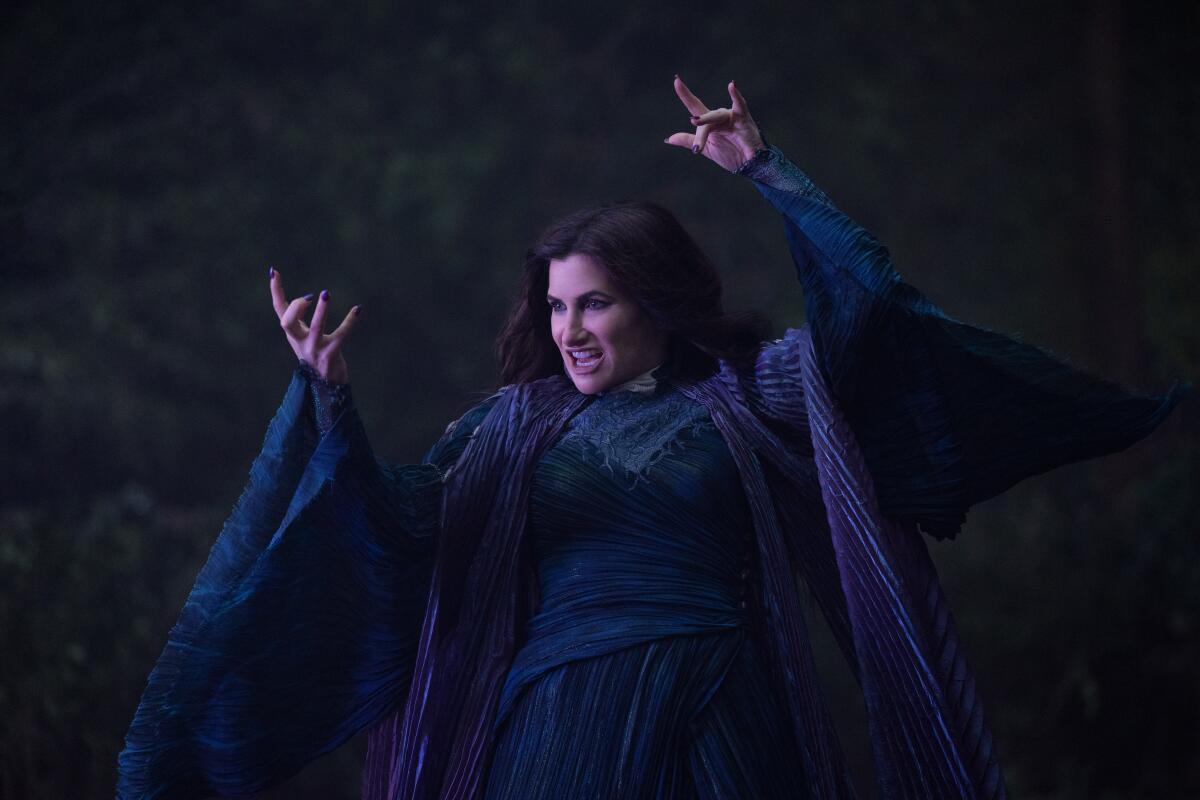 Kathryn Hahn, as Agatha Harkness, in a blue dress with her arms raised to use magic in "Agatha All Along."