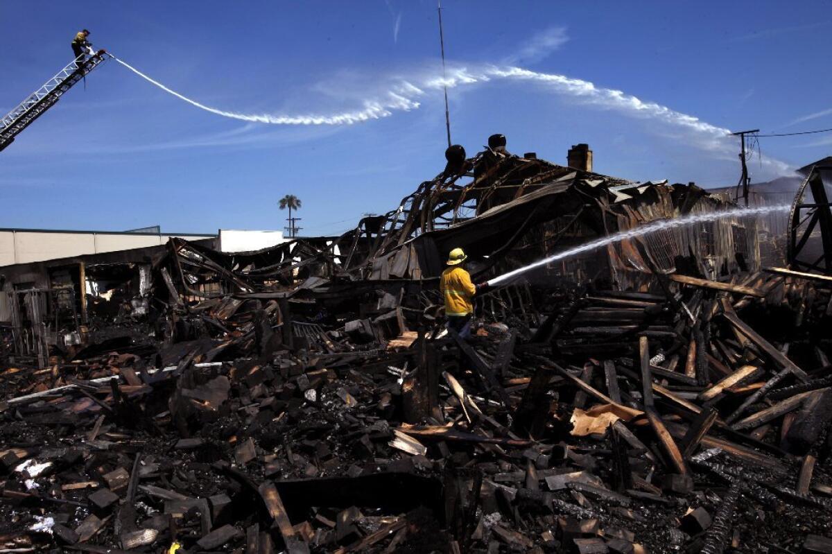 Firefighters host down hot spots after a major fire broke out early Saturday in North Hollywood and destroyed a pallet company and the San Fernando Valley Rescue Mission.