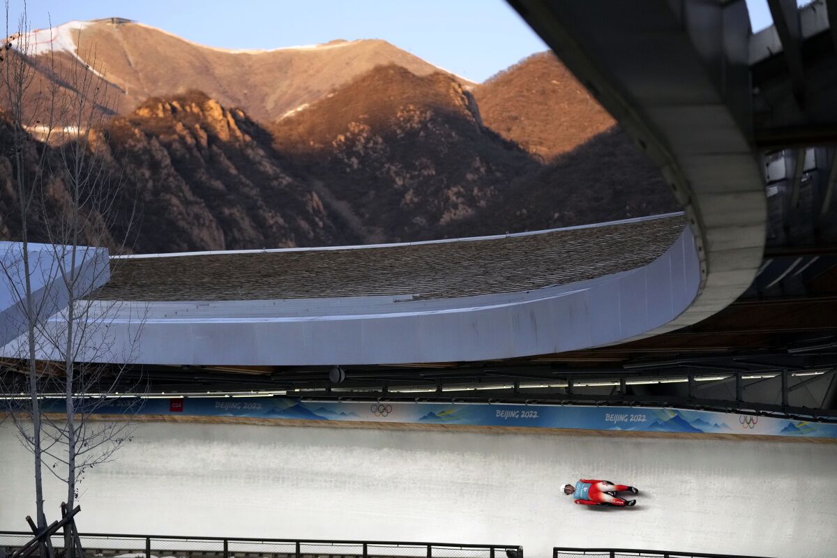 Mateusz Sochowicz of Poland speeds down the track during a men's luge training run at the 2022 Winter Olympics, Thursday, Feb. 3, 2022, in the Yanqing district of Beijing. (AP Photo/Mark Schiefelbein)