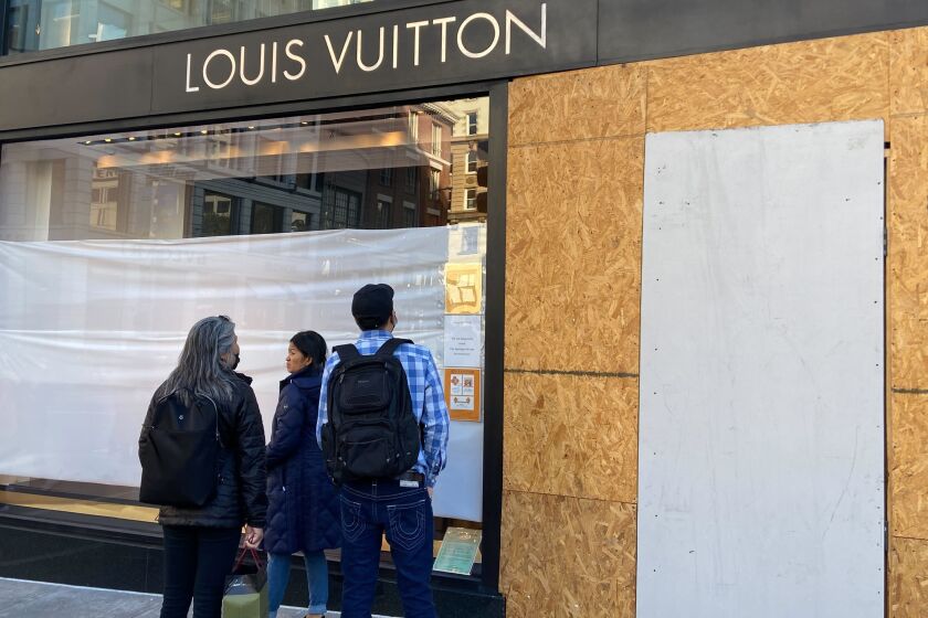 Union Square visitors look at damage to the Louis Vuitton store on Sunday, Nov. 21, 2021, after looters ransacked businesses late Saturday night in San Francisco. (Danielle Echeverria/San Francisco Chronicle via AP)