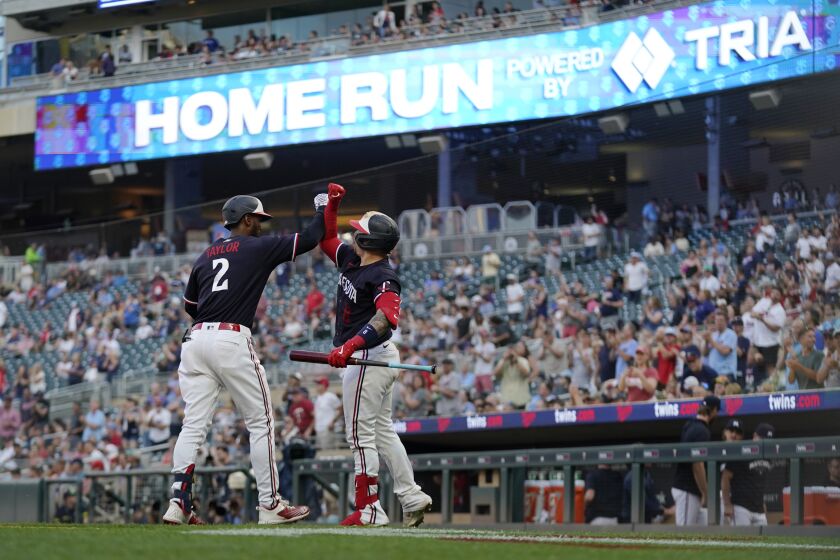 Minnesota Twins' Michael A. Taylor (2), left, celebrates with Christian Vazquez after hitting a solo home run during the fifth inning of a baseball game against the Cleveland Guardians, Thursday, June 1, 2023, in Minneapolis. (AP Photo/Abbie Parr)