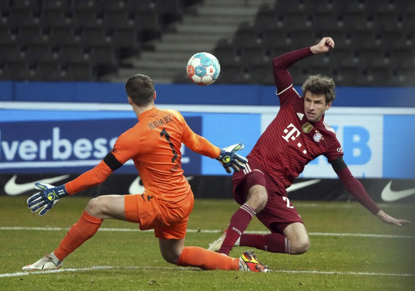 Thomas Mueller del Bayern Múnich intenta disparar mientras lo defiende el portero del Hertha Berlin Alexander Schwolow en el encuentro de la Bundesliga el domingo 23 de enero del 2022. (Soeren Stache/dpa via AP)