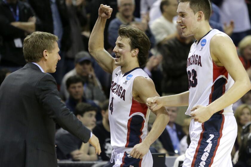 Gonzaga Coach Mark Few celebrates with Kevin Pangos, center, and Kyle Wiltjer late in the second half of their victory over Iowa on Sunday.