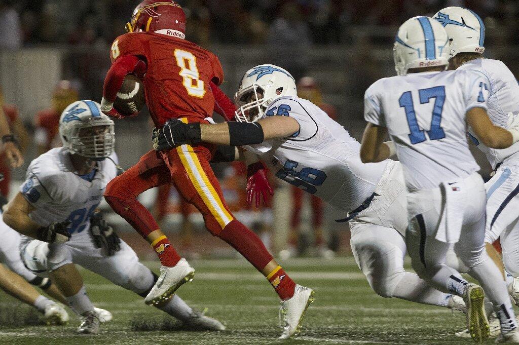 Corona del Mar High's Joe Anderson wraps up Woodbridge's Nick Nash (8) for a tackle.