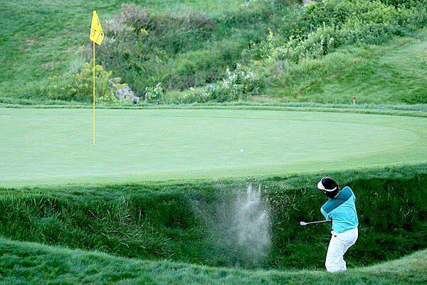 Bubba Watson hits from the bunker behind the 18th green during the third playoff hole on Sunday at the PGA Championship. Watson had landed in the bunker following a drop after he hit into the water in front of the green.