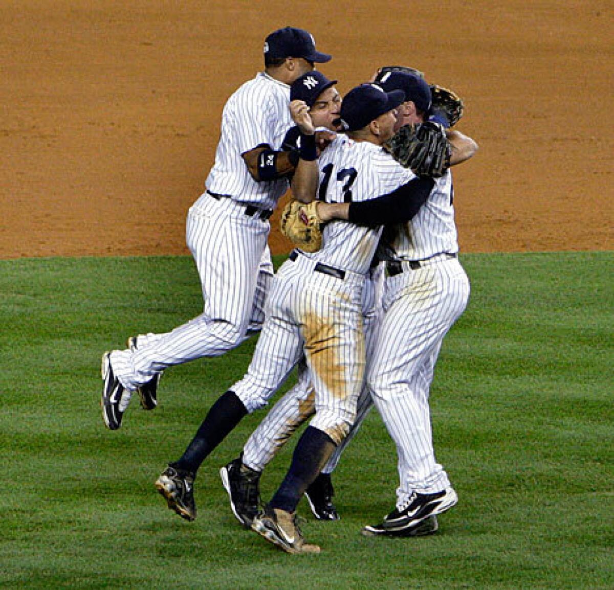 Yankees infielders Robinson Cano, left, Alex Rodriguez (13), Mark Teixeira, right, and Derek Jeter celebrate their 5-2 victory over the Angels in Game 6 of the American League Championship Series at Yankee Stadium on Sunday night that clinched a berth in the World Series.
