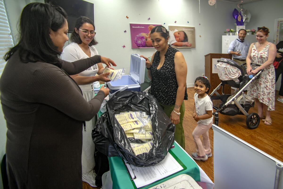 Marketing Manager Angelica Rosa and Jasmine Rivera of Mothers Milk Bank pack up containers.
