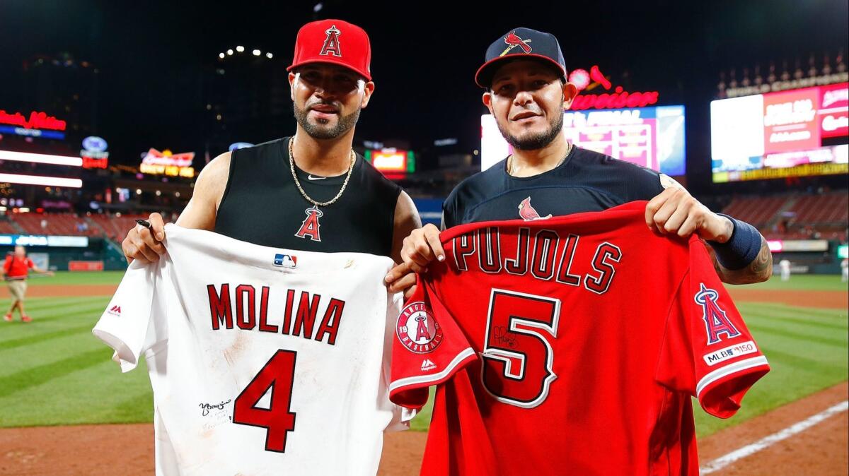 Angels slugger Albert Pujols, left, and St. Louis Cardinals catcher Yadier Molina exchange jerseys after Sunday's game.