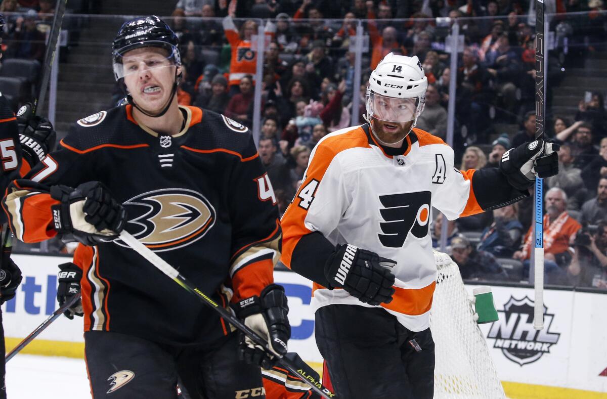 Philadelphia Flyers forward Sean Couturier, right, celebrates next to Ducks defenseman Hampus Lindholm after scoring during the first period of the Ducks' 2-1 overtime loss Sunday.