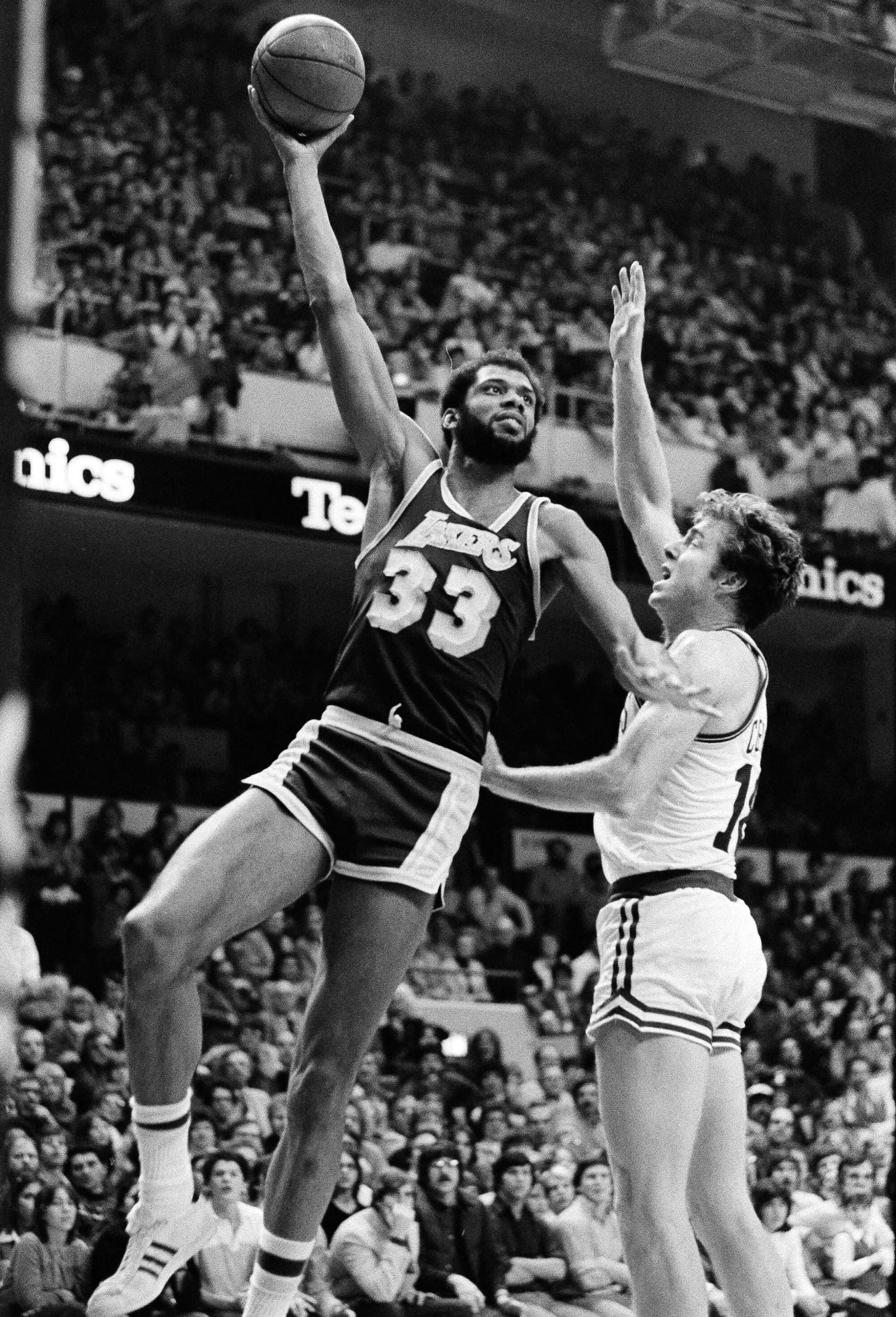 Lakers center Kareem Abdul-Jabbar shoots his famous sky hook over Celtics center Dave Cowens in 1980.