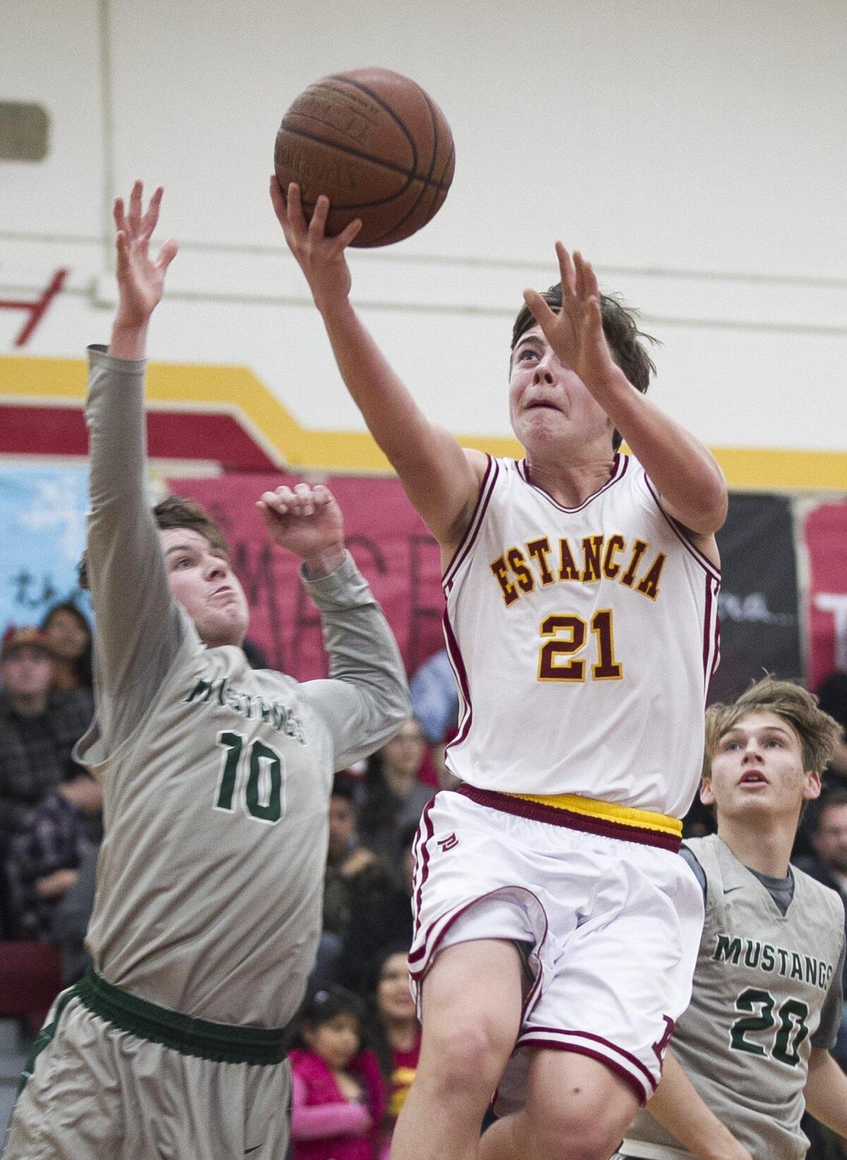 Estancia’s Alex Hendricks goes up for a shot against against Costa Mesa’s Ben Swanson during an Orange Coast League game on Wednesday.