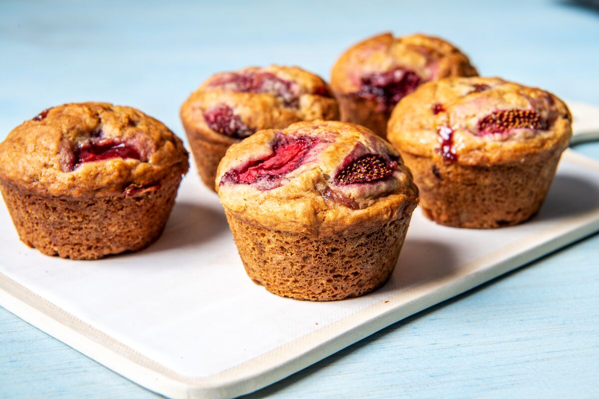 A photograph of five strawberry muffins.